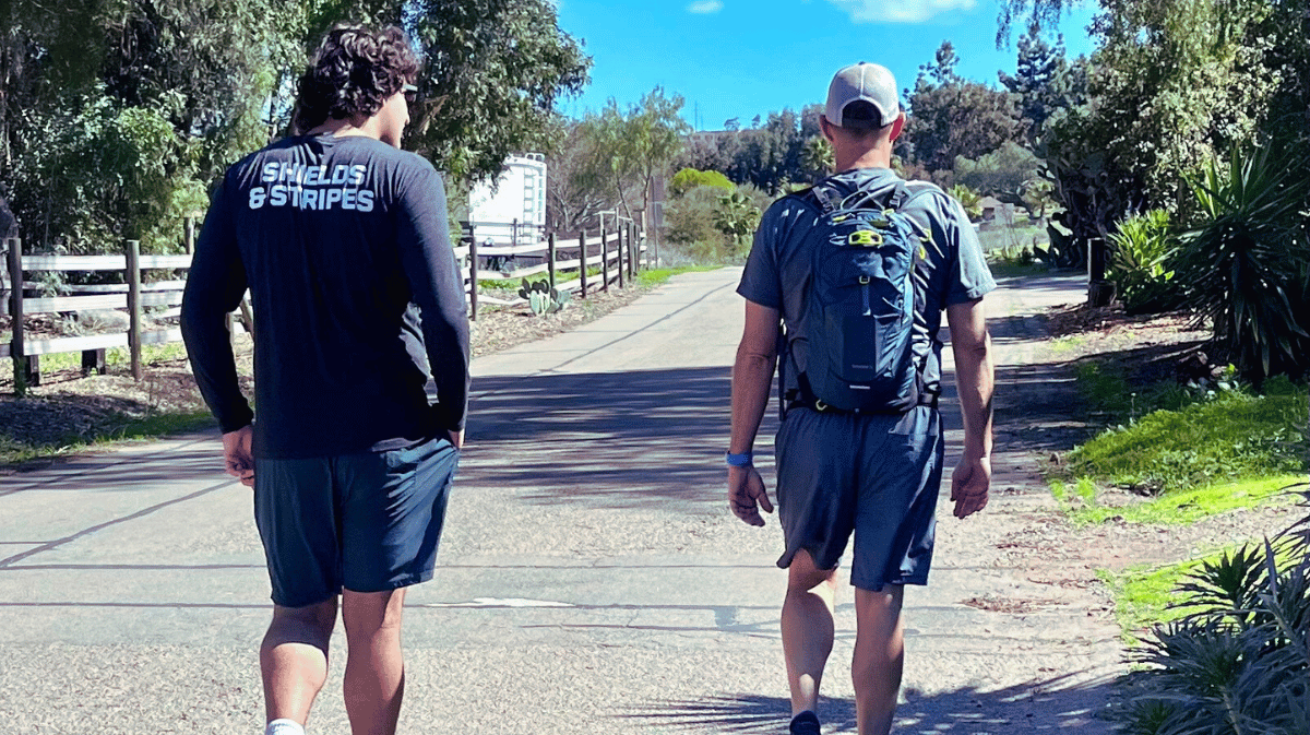 Shields & Stripes Chairman Rory Berke and his son hiking alongside each other.
